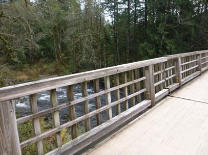 Wooden footbridge with railing – wooden surface with small open spaces between wood surfaces – view of Salmon River